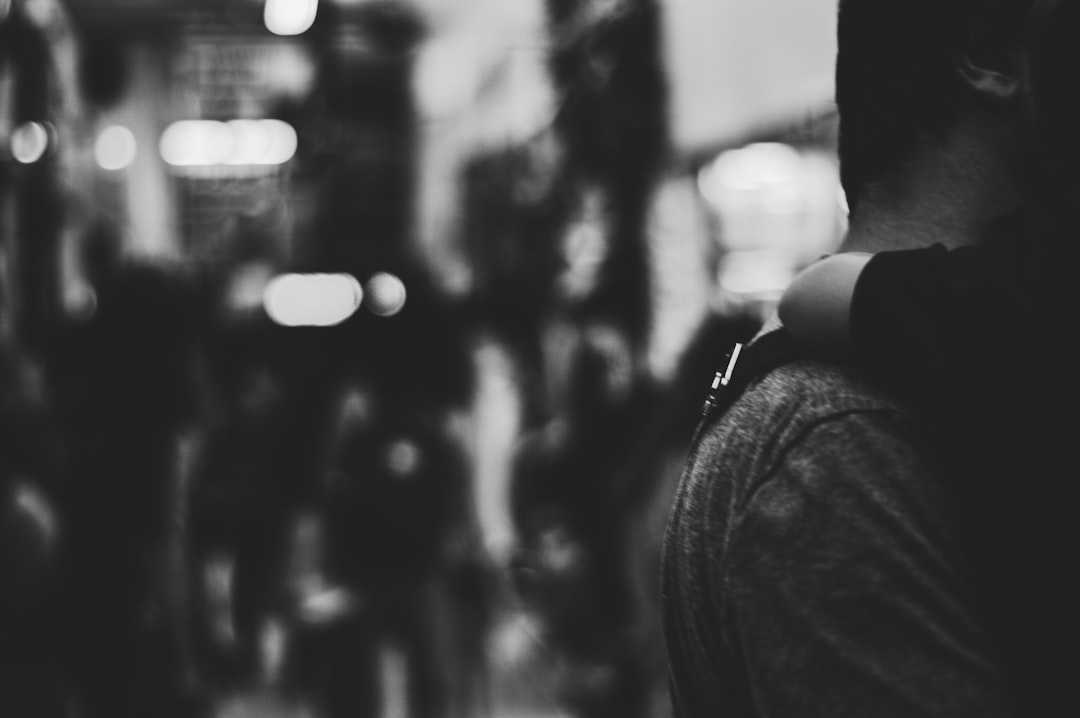 grayscale photography of a man carrying child