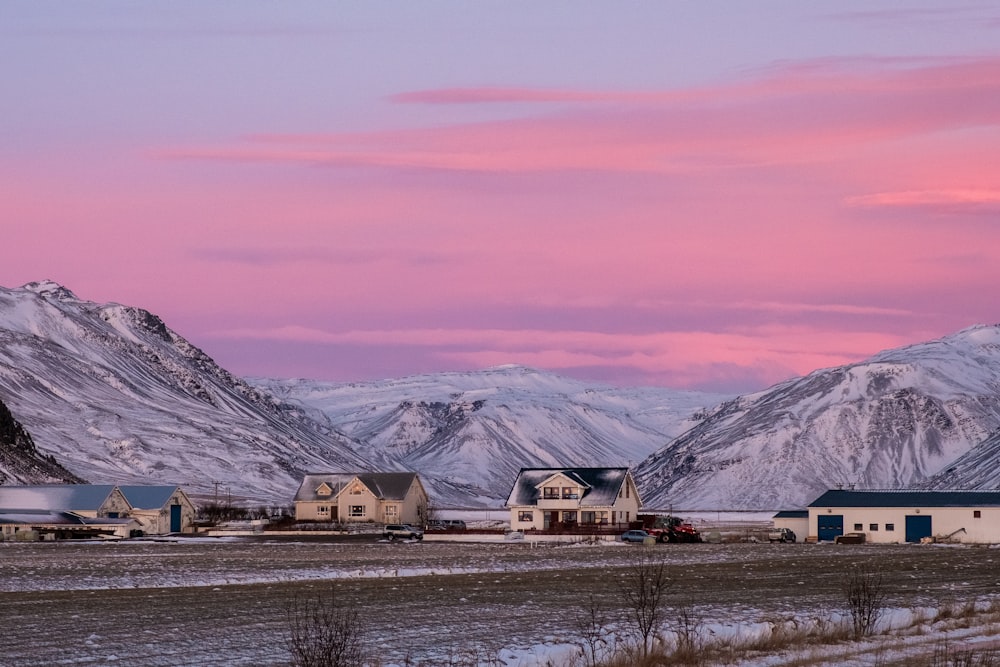 white houses near mountain cover by snow