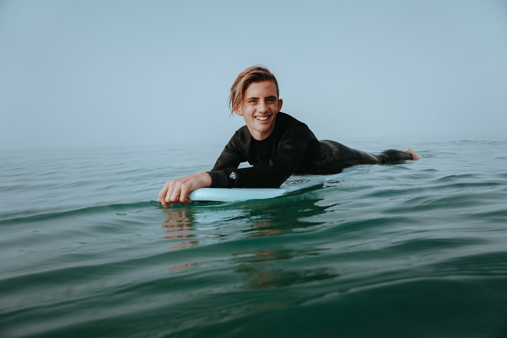 hombre sosteniendo la tabla de la rodilla en el cuerpo de agua