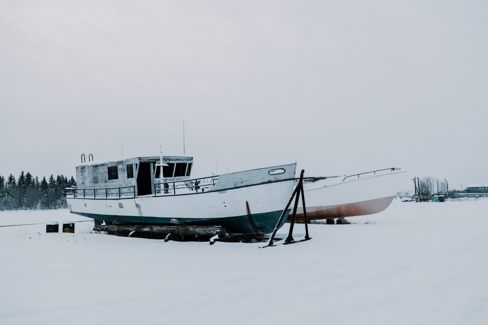 two boats on snow-covered field during daytime