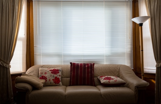 brown leather couch in front of window