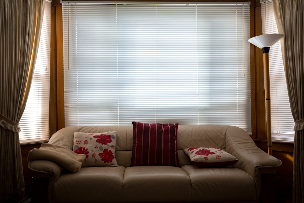 brown leather couch in front of window