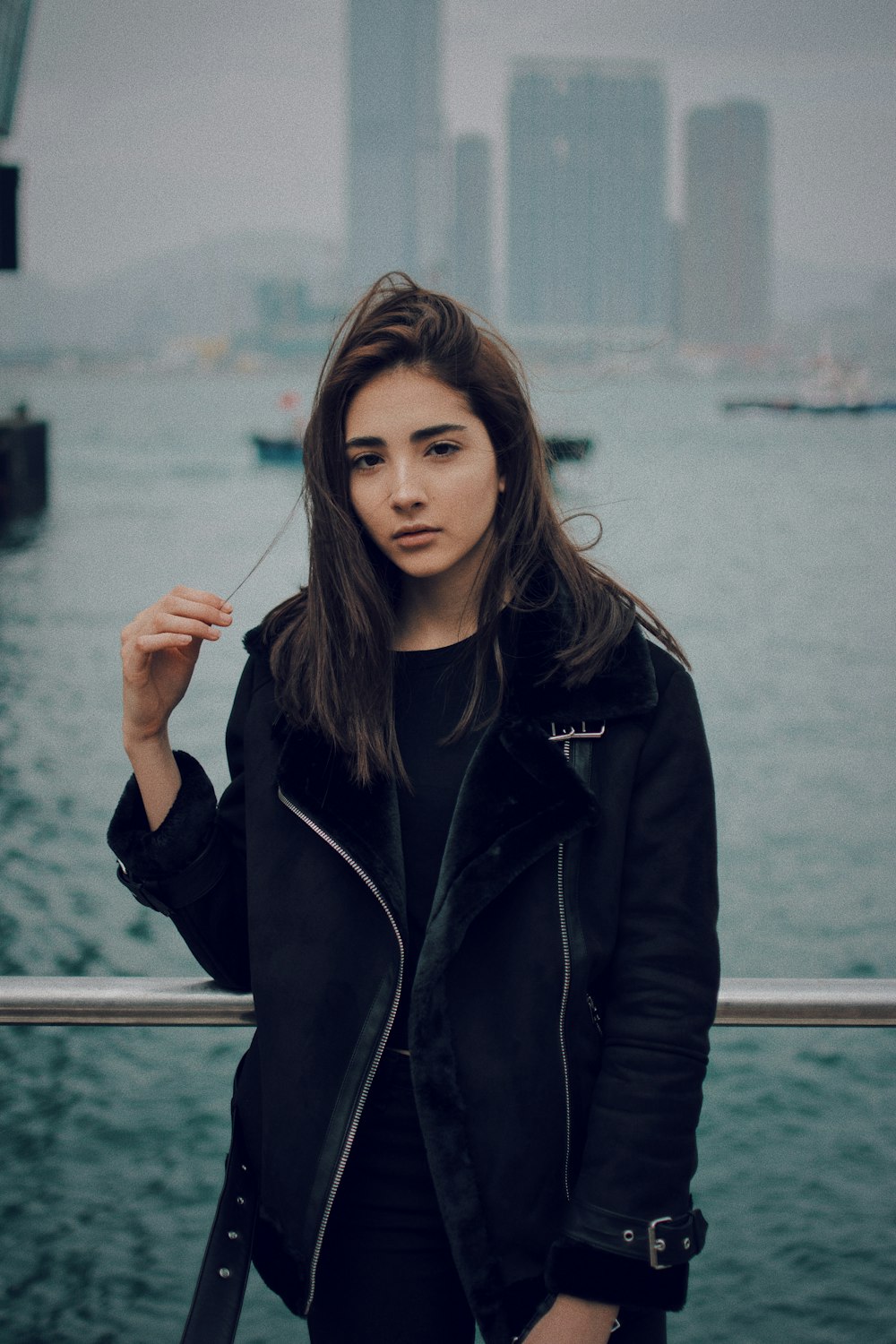 woman holding her hair standing near body of water