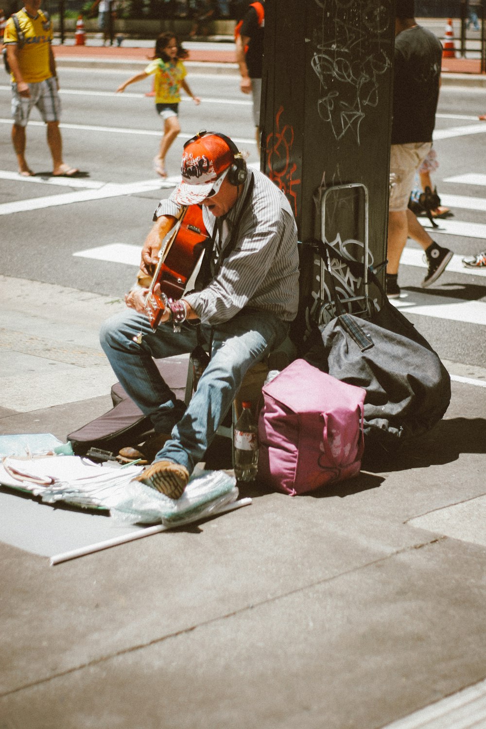 man playing guitar in front of post