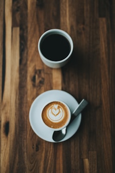 A steaming cup of coffee with rich foam art on top.