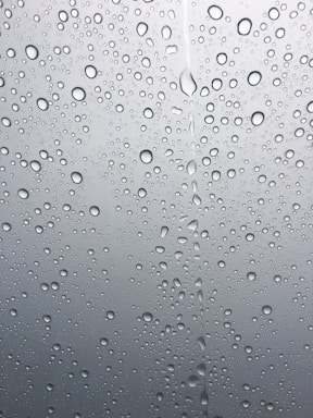 A clean, minimalistic image of a water droplet on a white background with subtle blue accents.