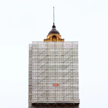 Picture of a nearly finished building with scaffolding and finishing touches being applied.