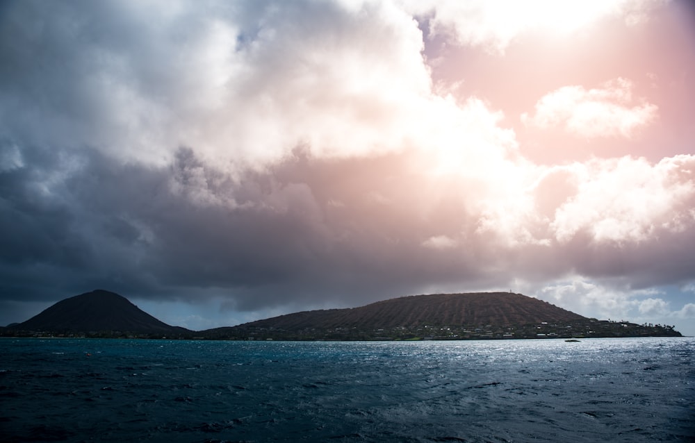 island beside body of water under cloudy sky