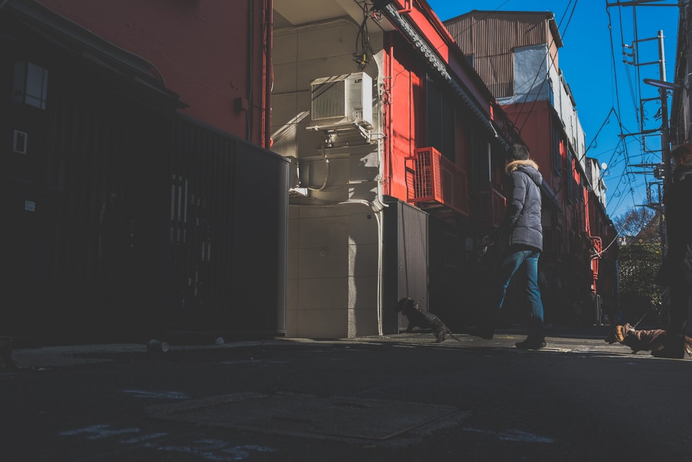 person walking towards white and red house