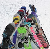 A collection of colorful ski and snowboard wax products displayed on a wooden table.