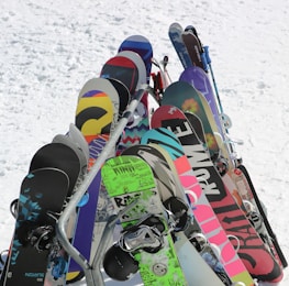 A collection of colorful ski and snowboard wax products displayed on a wooden table.
