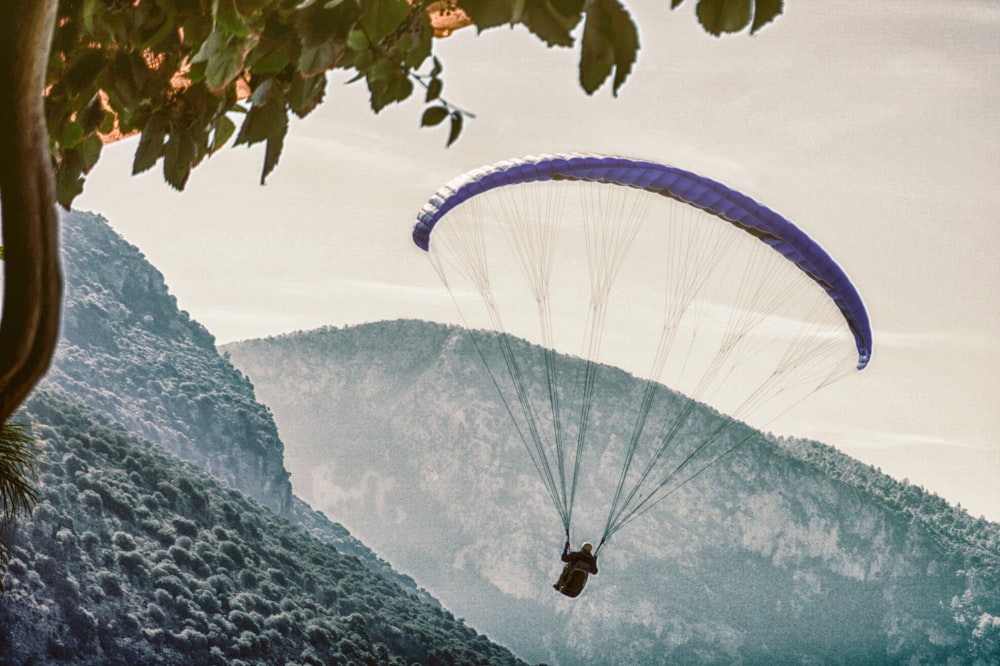 person on parachute near mountain