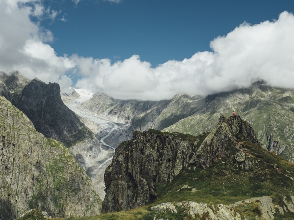 brown and green rock formation under blue and white clouds