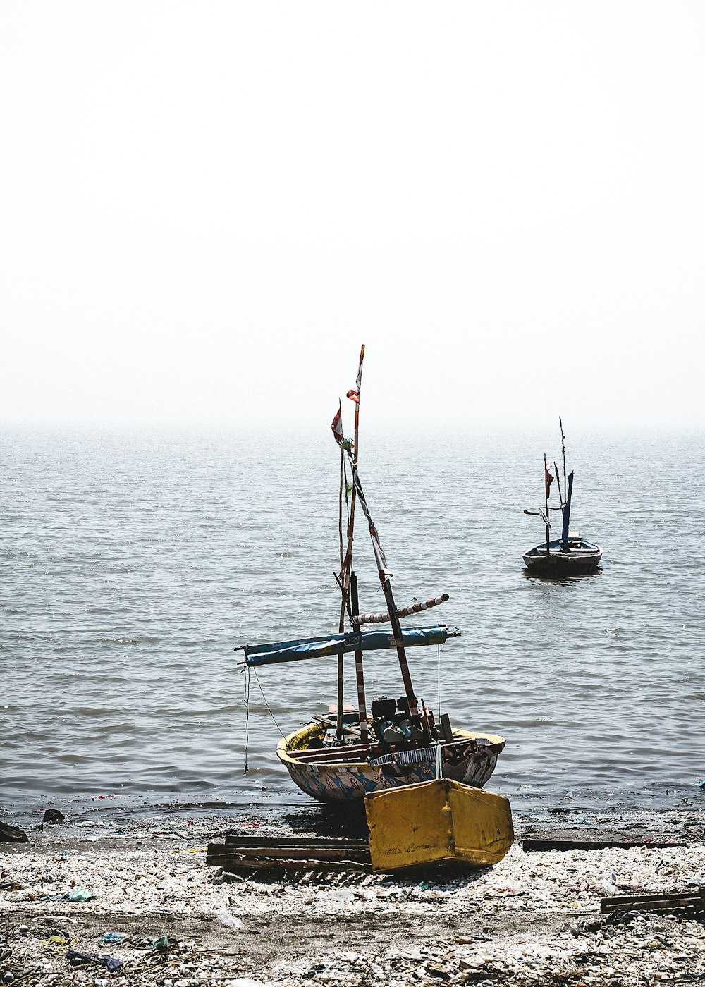 brown and gray sailboat near shore