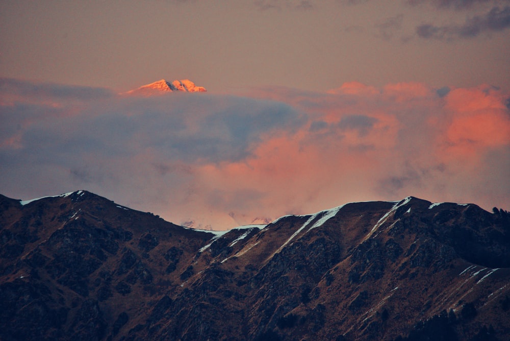 bird's eye view of mountain peak over clouds