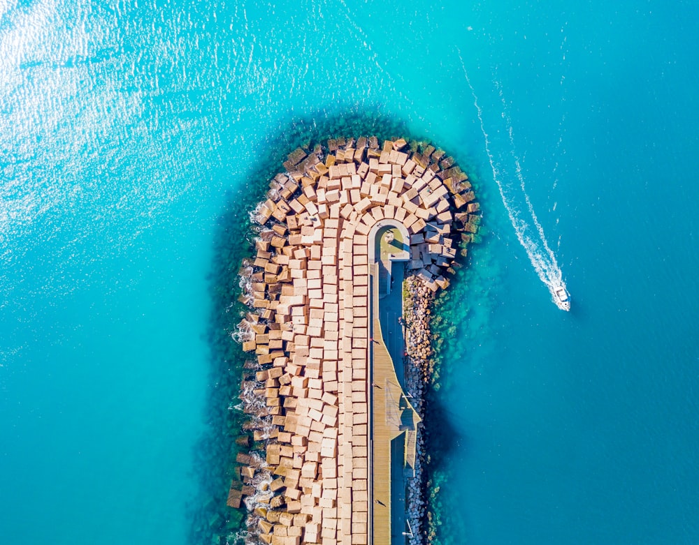 Fotografía aérea de un barco blanco cerca de la isla durante el día