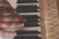Close-up of hands practicing piano scales on a classic acoustic piano.