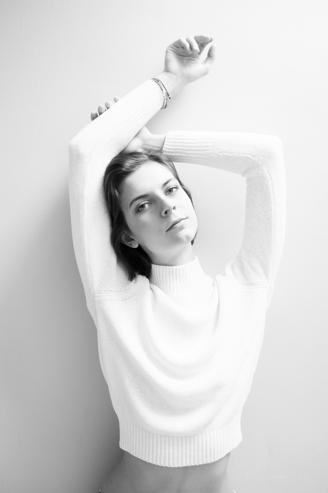 grayscale photography of woman leaning on wall