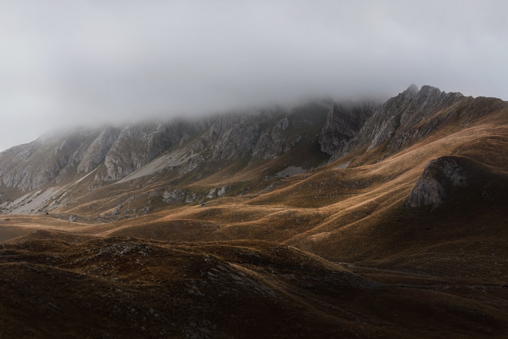 Fotografia de paisagem da montanha cinzenta sob torrões brancos