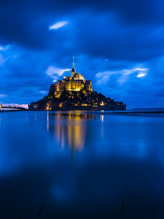 brown castle on body of water in Mont Saint-Michel France