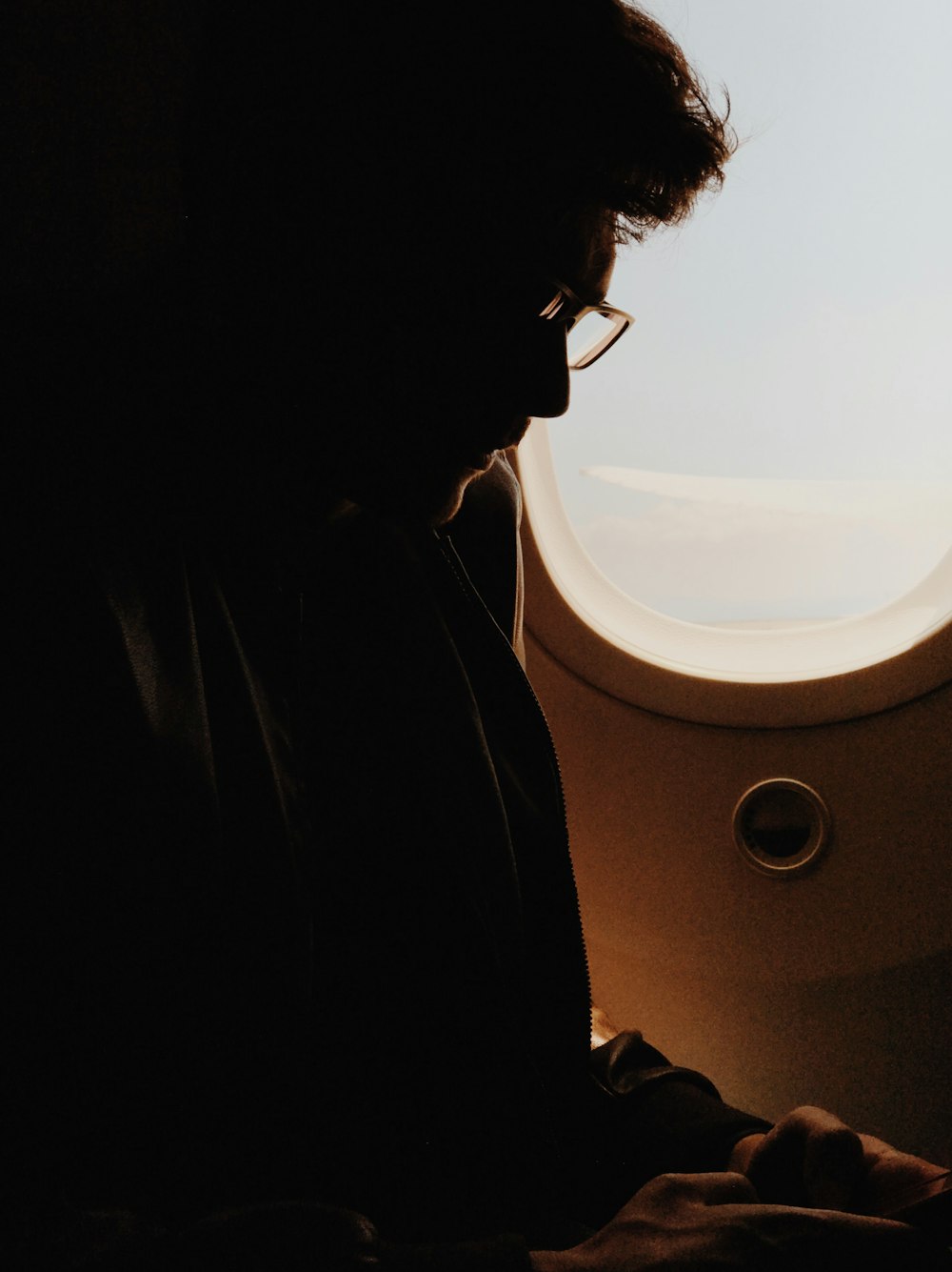 silhouette photography of man sitting in airplane seat