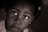 A close-up portrait of a young child gazing upwards. The image is in a sepia tone with soft lighting that emphasizes the child's expressive eyes. A subtle focus on the emotions conveyed through the child's facial expression.