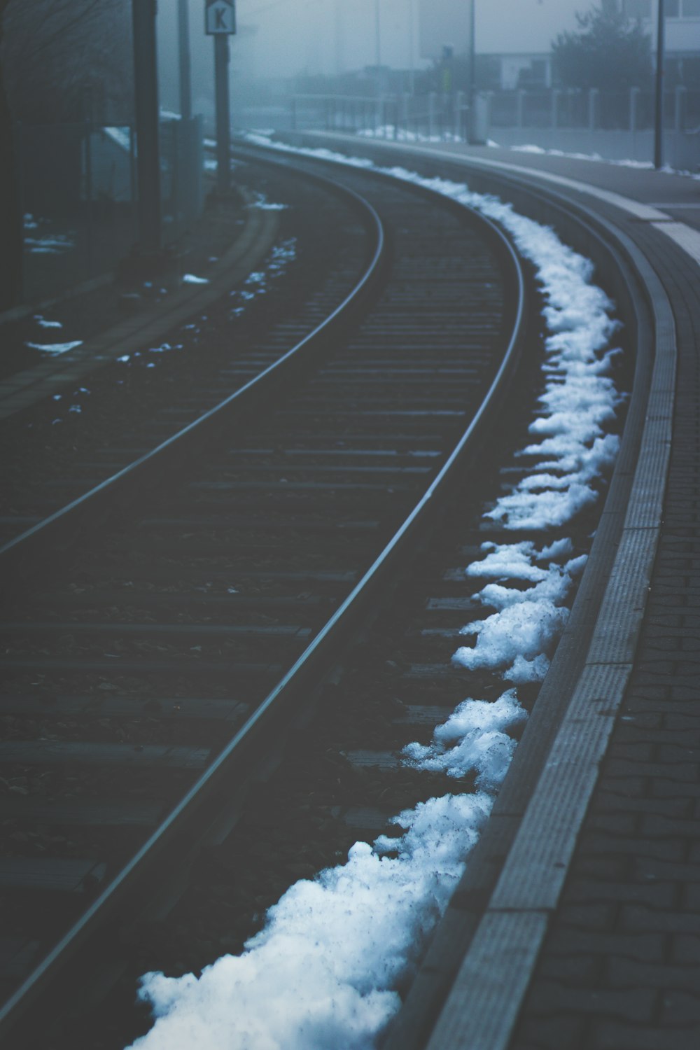 low light photography of train rails under foggy sky