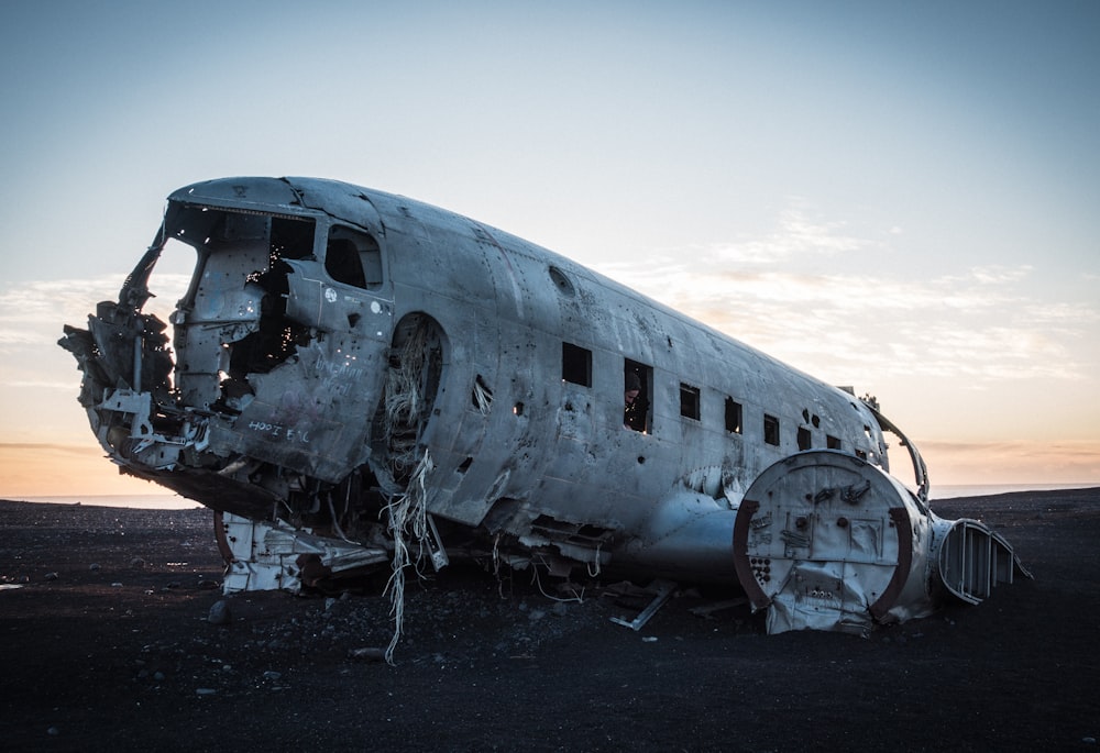 épave d’avion de ligne blanche au sol pendant la journée