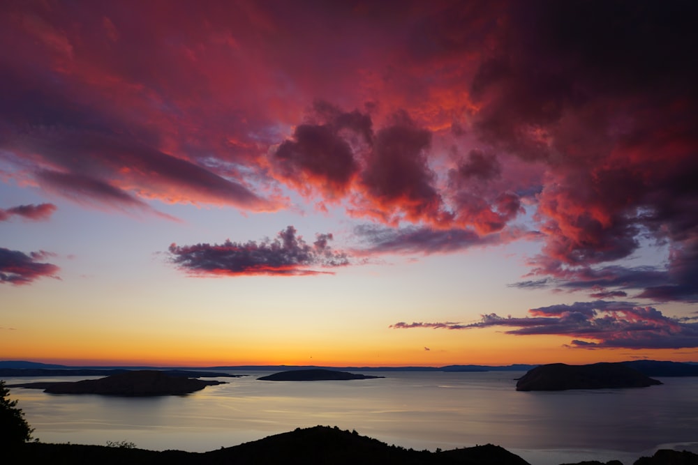 silhouette of island during red and blue cloudy day