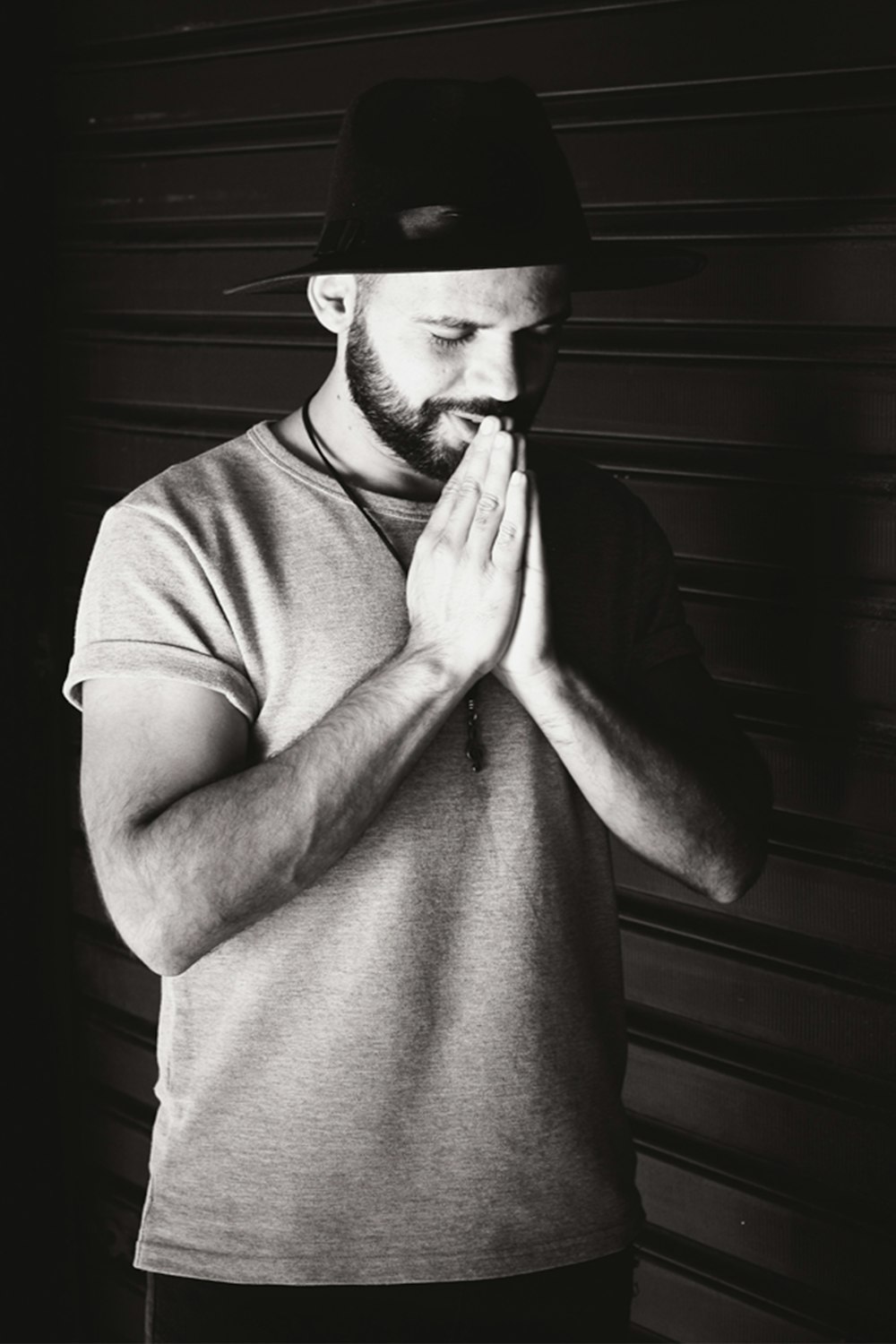 grayscale photography of a man praying