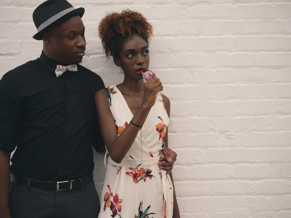 man and woman standing in front of white painted wall