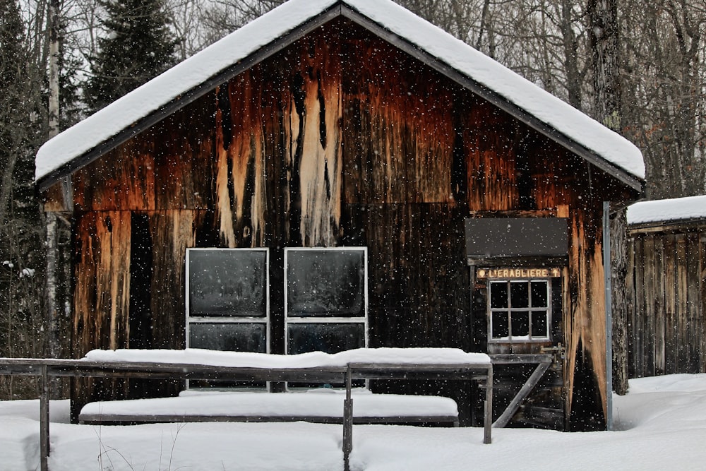 casa de madeira marrom coberta pela neve