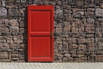 red 2-panel door on black metal chain link board