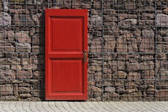 red 2-panel door on black metal chain link board