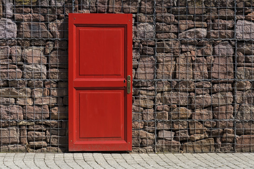 red 2-panel door on black metal chain link board