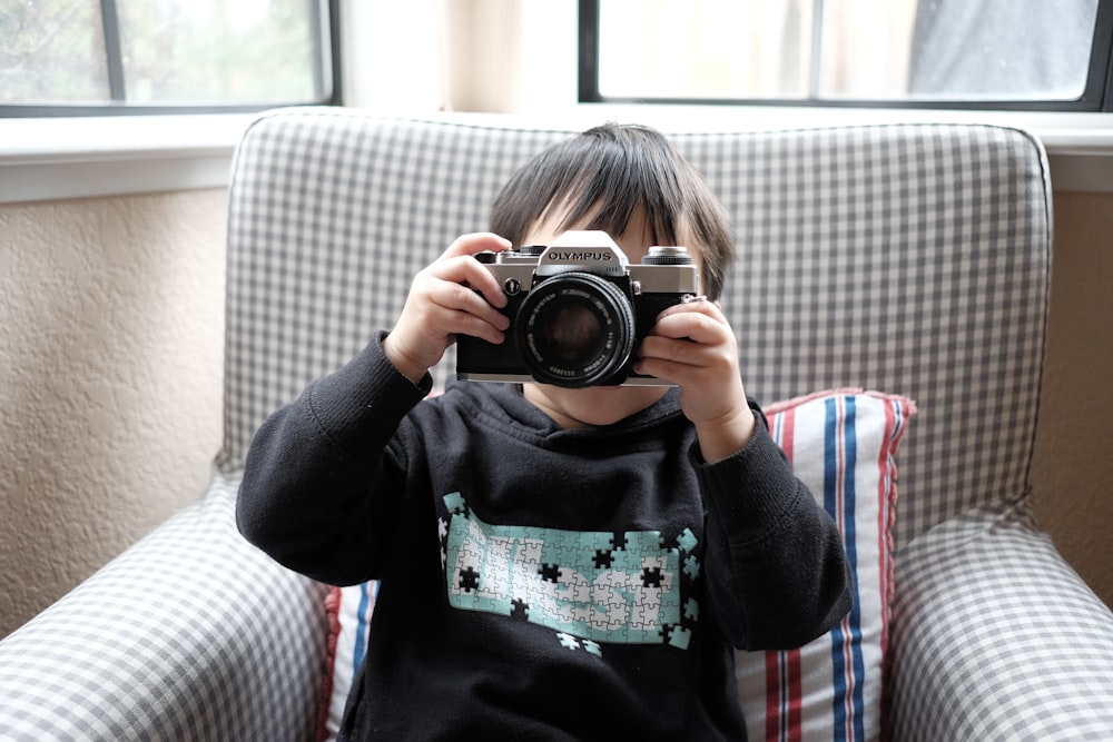 menino segurando a câmera DSLR