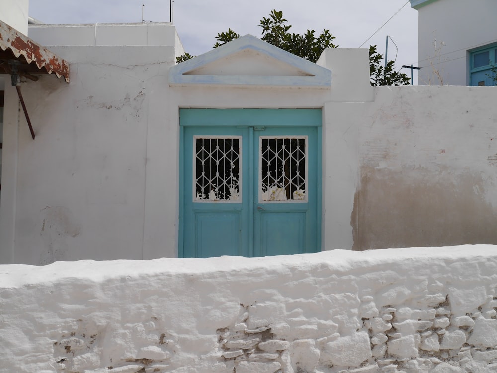 white house with blue double-door gate