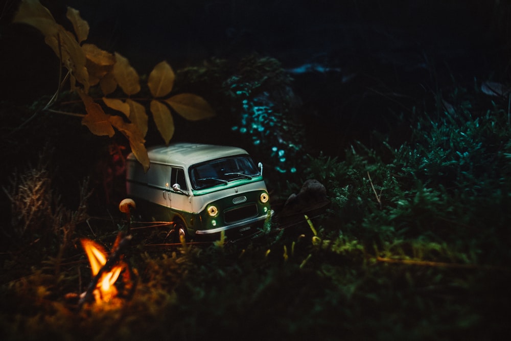 white vehicle passing road near trees at night time