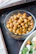 A vibrant bowl of roasted chickpeas with herbs and a sprinkle of sea salt.