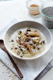 A warm bowl of oat porridge with cinnamon and sliced bananas on a cozy kitchen counter