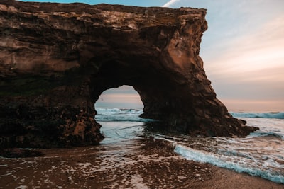 photo of rock formation near shoreline during daytime santa's elves teams background