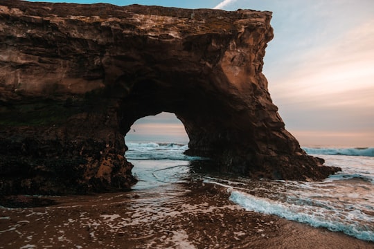 photo of rock formation near shoreline during daytime in Santa Cruz United States