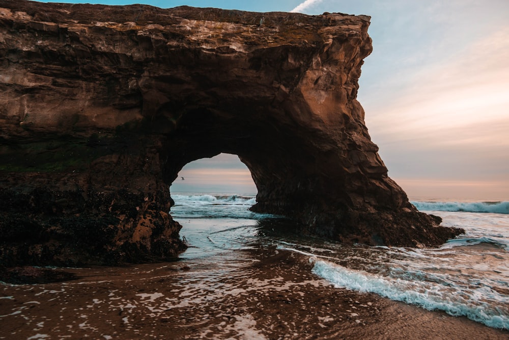 photo of rock formation near shoreline during daytime