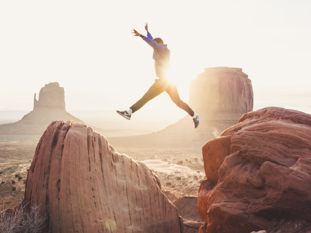 man jumping between two rocks