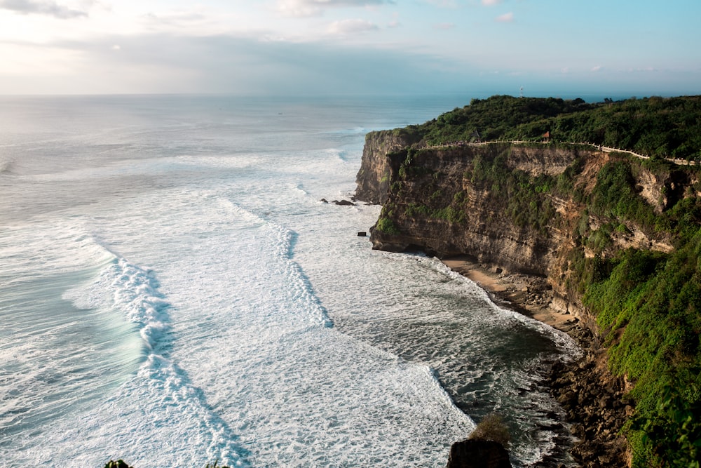 body of water near green cliff