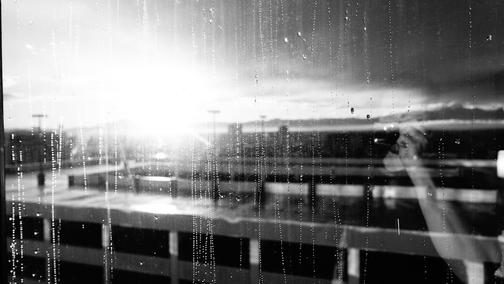 grayscale photo of window with water droplets