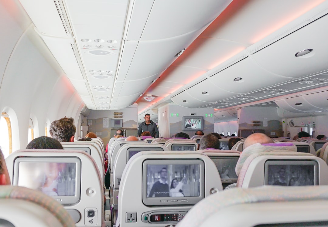 man walking down the aisle of airplane, Emirates airline seating