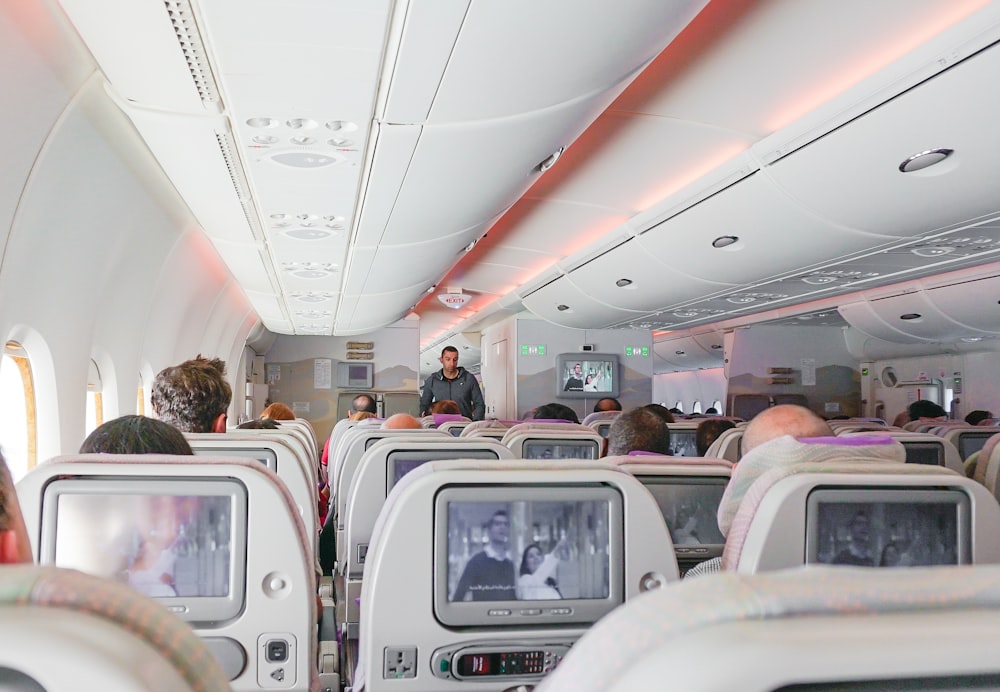 man walking down the aisle of airplane