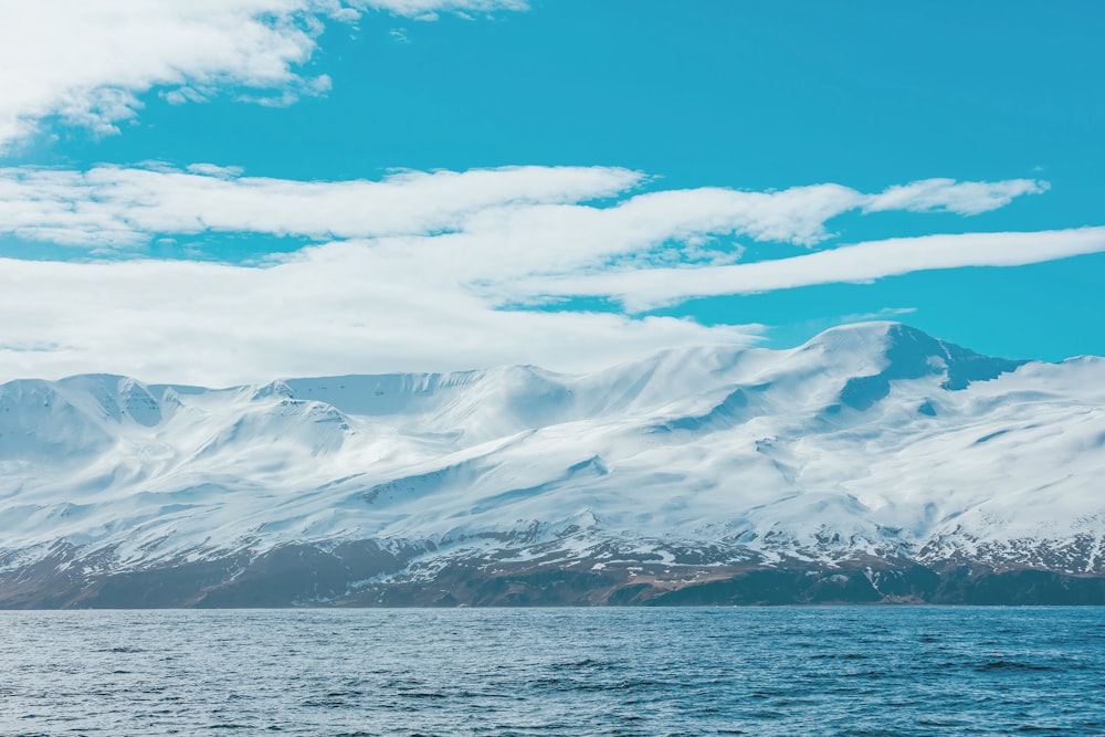 mountain covered with snow under white clouds