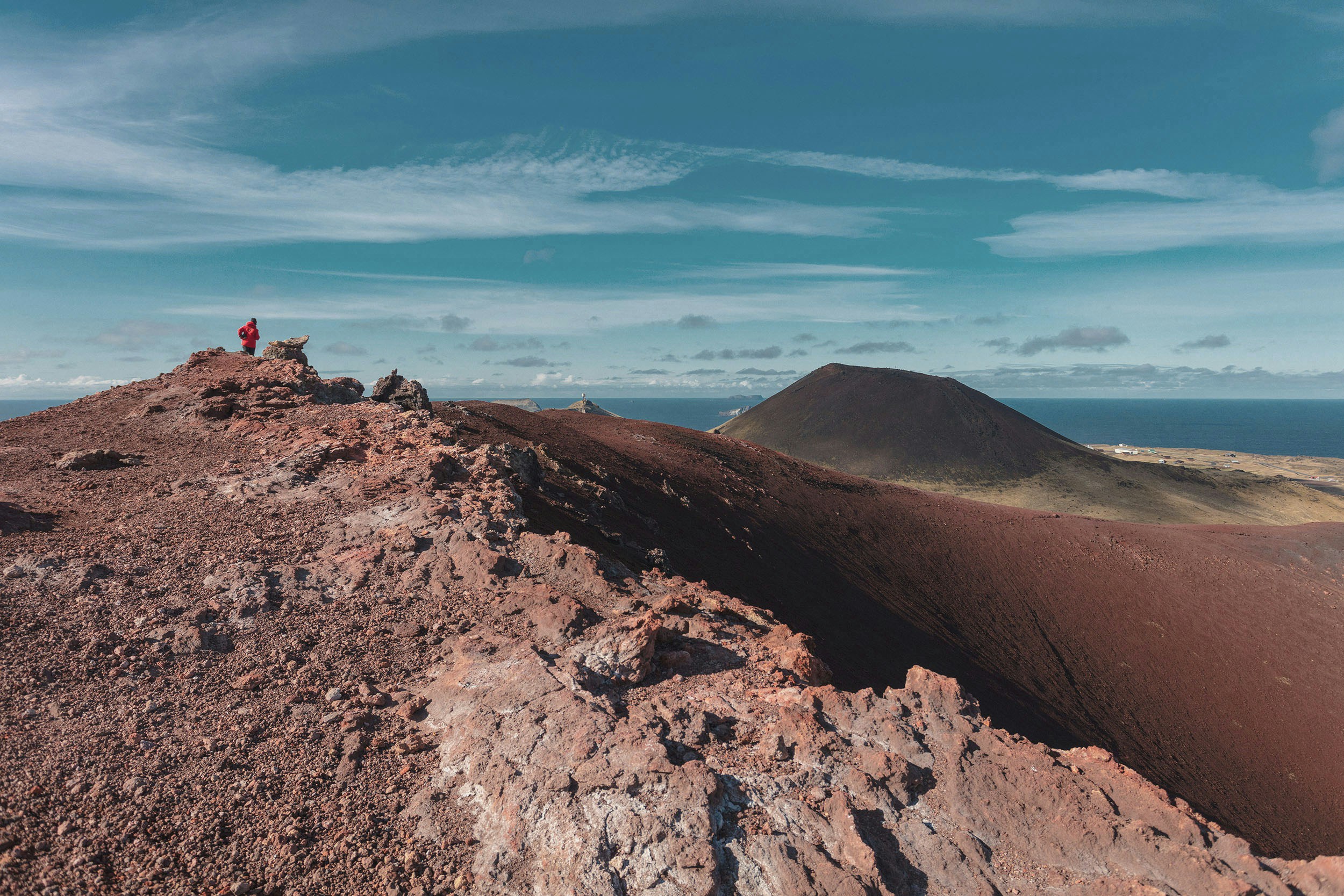 photo of person standing at peaked of mountain